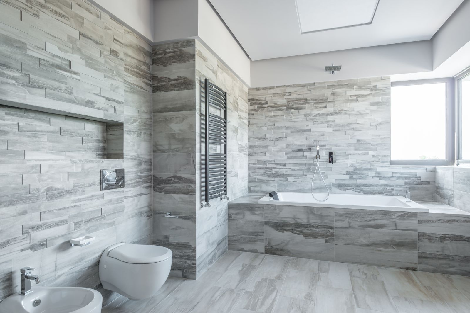 Kenter Canyon Spa Bath — guest bathroom with natural stone tile and heated flooring